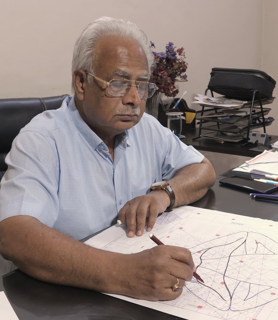 Pt. Satish Sharma at his desk, drafting a Vastu plan